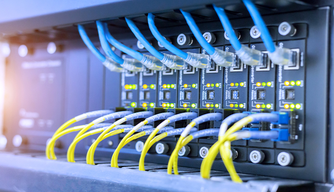 Anetwork switch with multiple ethernet cables plugged into it.